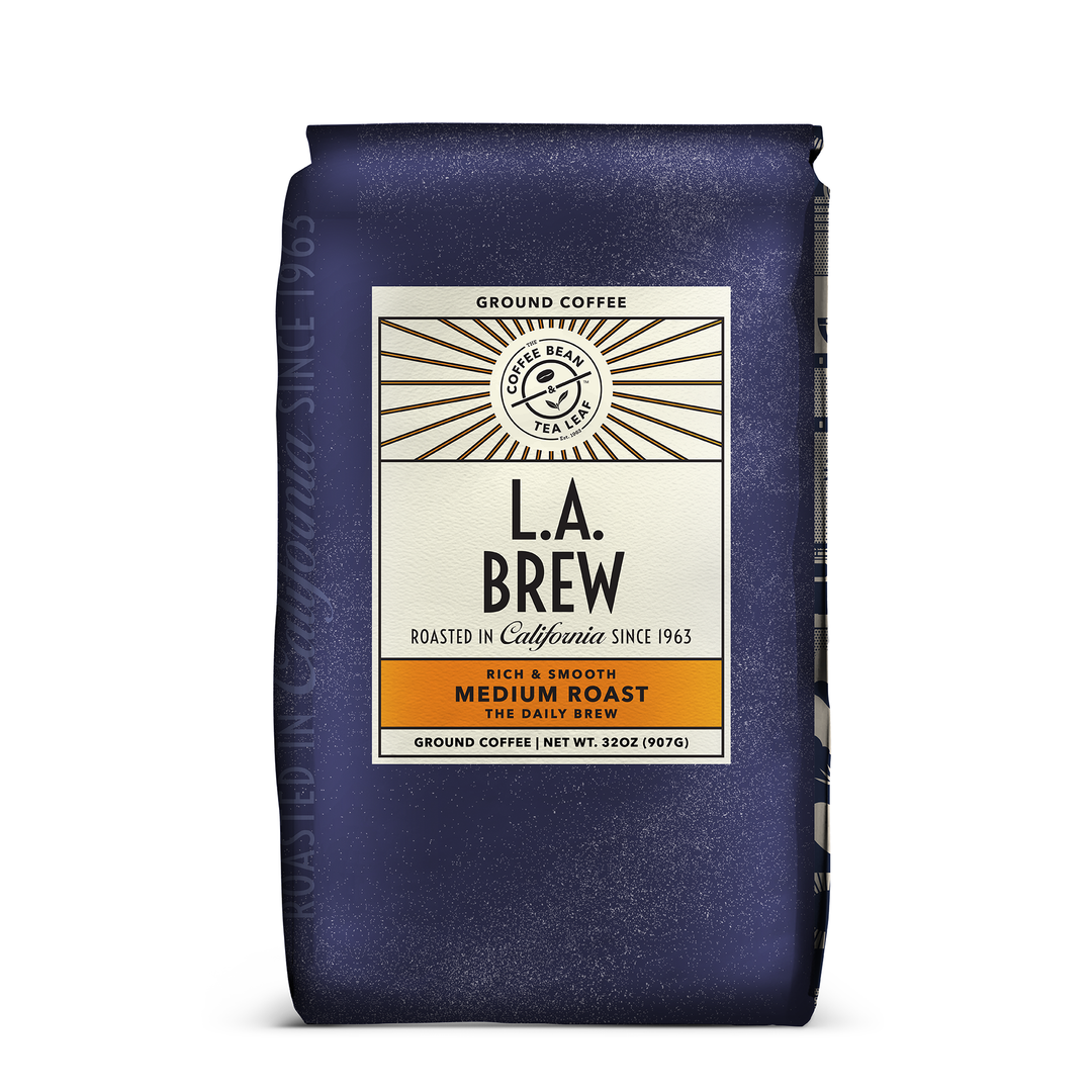 A purple 32oz bag of L.A. Brew coffee from The Coffee Bean & Tea Leaf. Artwork has the Coffee Bean & Tea Leaf logo on a beige sticker, that states it's roasted in California since 1963 and that it is a Rich & Smooth Medium Roast.