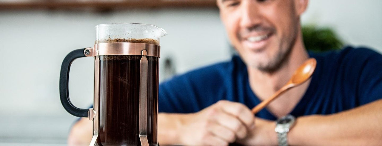 Man Looking at Cup of Coffee with a Spoon