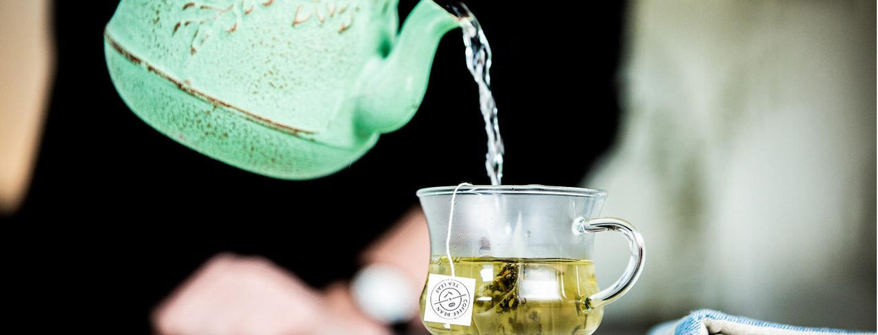 Pot of water being poured in a tea cup