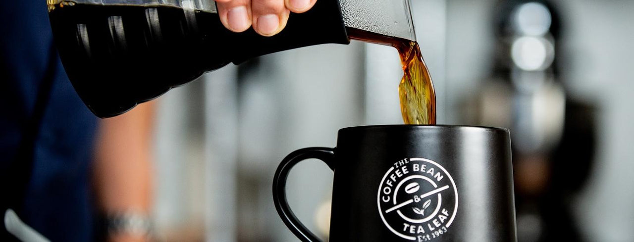 Person pouring coffee into mug