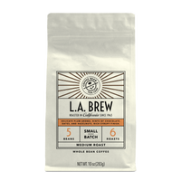 10oz cream bag labeled “L.A. Brew” on a white background. The design shows the coffee is Roasted in California, has a delicate plum aroma with hints of chocolate dates and hazelnut with a rich syrupy finish and is Medium, Ground.