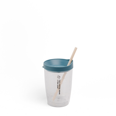 A clear plastic travel tumbler with a teal lid and a light wood straw, featuring the text 'THE COFFEE BEAN TEA SHOP' printed vertically on the front, set against a plain white background.