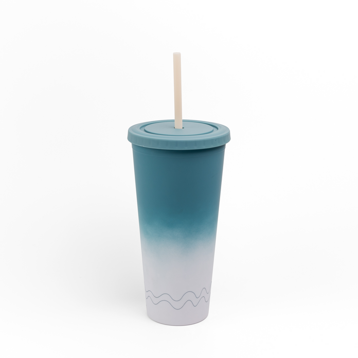 A tall insulated tumbler with a lid and straw, featuring a blue-to-white gradient design and a subtle wave pattern near the bottom, shown on a plain white background.