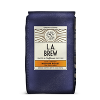 A purple 32oz bag of L.A. Brew coffee from The Coffee Bean & Tea Leaf. Artwork has the Coffee Bean & Tea Leaf logo on a beige sticker, that states it's roasted in California since 1963 and that it is a Rich & Smooth Medium Roast.