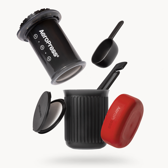 Aeropress coffee maker with red lid on a white background