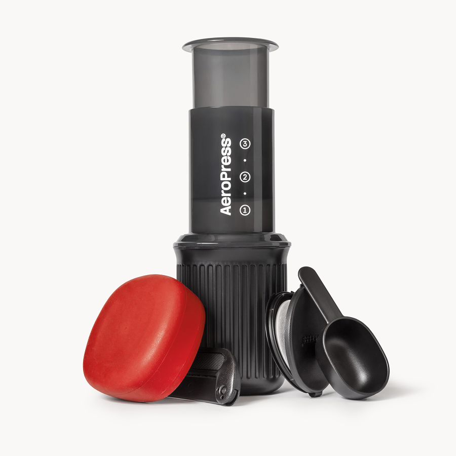 Aeropress coffee maker with red lid on a white background