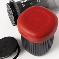 Aeropress coffee maker with red lid on a white background