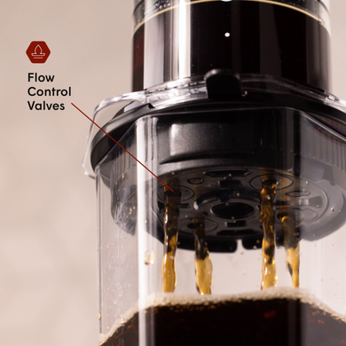 Close-up of an AeroPress coffee press with flow control valves highlighted.