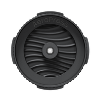 Black AeroPress coffee brewing component on a white background
