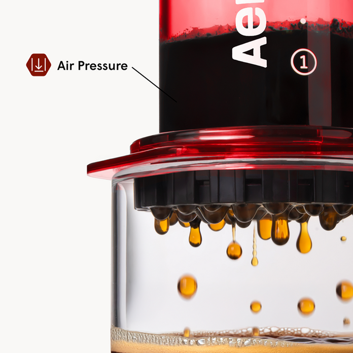 Close-up of a coffee brewing device with air pressure indicator and liquid dripping.