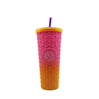 Gradient pink to orange tumbler with textured surface and straw on a white background