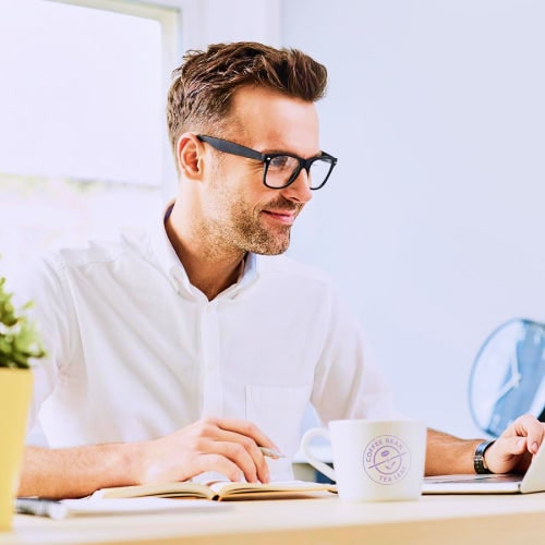 Man working from home on a laptop with a coffee mug